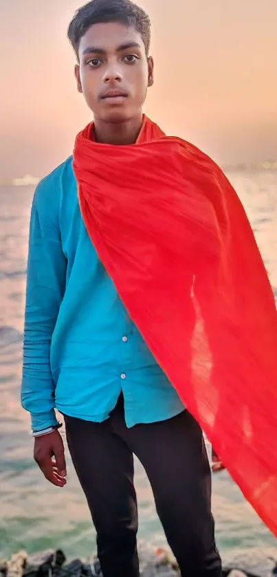 Portrait with a red scarf by the sea during a sunset, featuring vibrant colors.