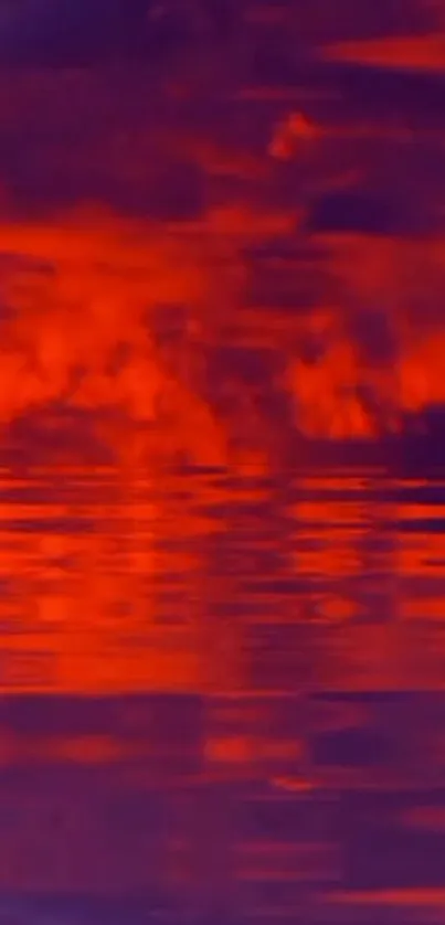 Red sunset reflected over water with clouds and purple accents.