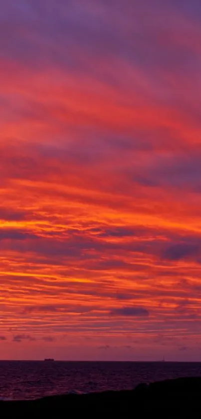 Sunset with vivid orange and purple hues, featuring a silhouetted figure by the sea.