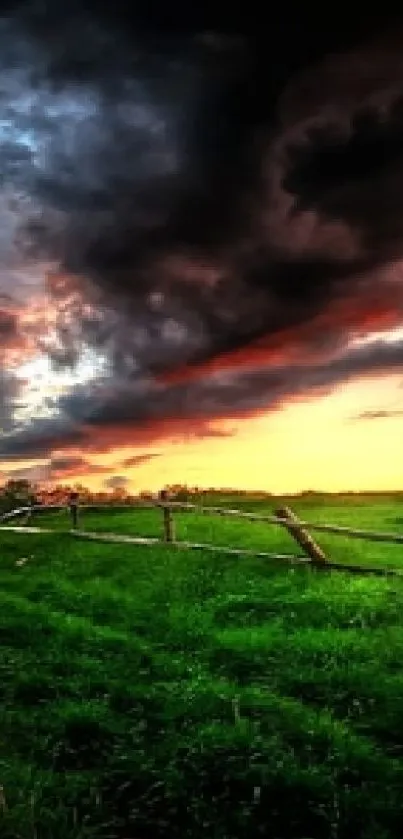 Vibrant sunset with dramatic clouds over lush green fields.