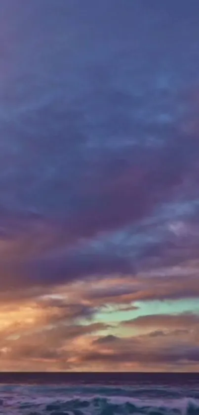 Vibrant sunset sky with purple clouds over ocean.