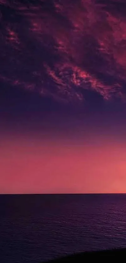 Vibrant pink and purple sunset over a tranquil ocean scene.