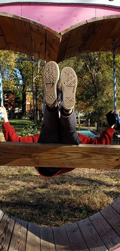 Person on a heart-shaped swing in a vibrant autumn park setting.