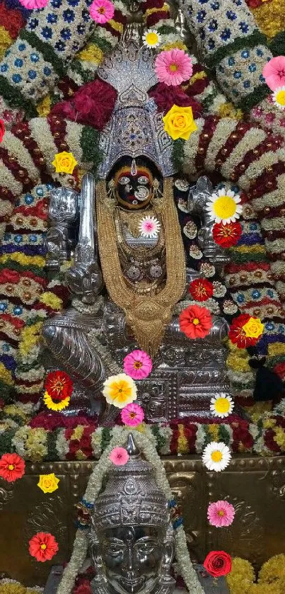 Deity adorned with colorful garlands in a vibrant temple scene.