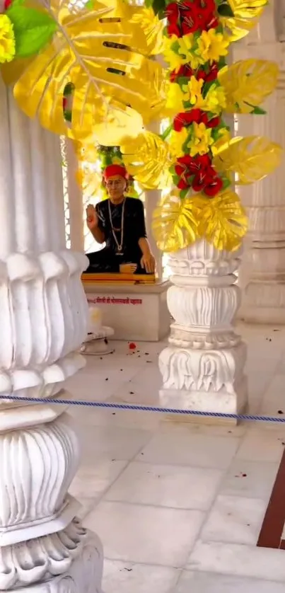 Ornate temple with yellow and red floral decor on marble pillars.