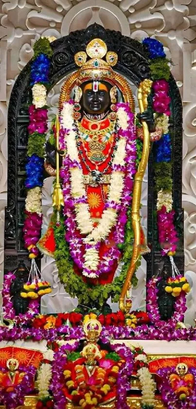 Vibrant deity adorned with colorful garlands in a temple setting.