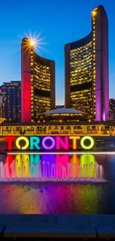 Toronto cityscape at night with colorful skyline reflected in water.