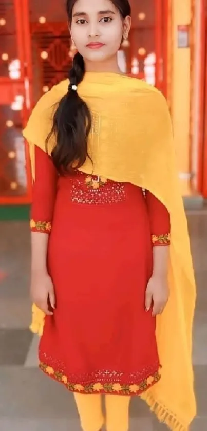 Woman in red dress with yellow scarf, traditional look.
