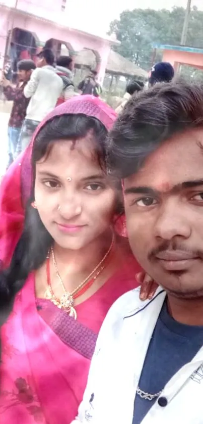 Couple in traditional attire posing outdoors with vibrant colors and cultural fashion.