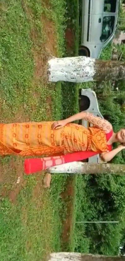 Woman in vibrant traditional saree amidst lush greenery.