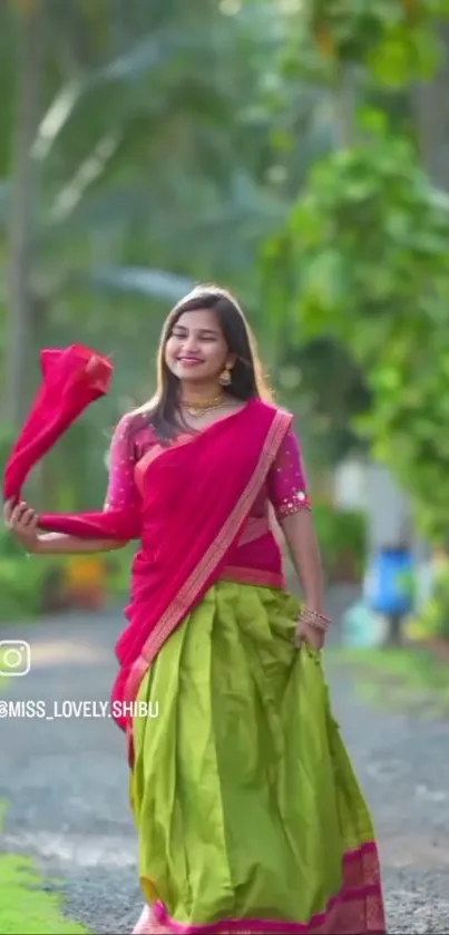 Woman in vibrant traditional attire outdoors in lush green setting.