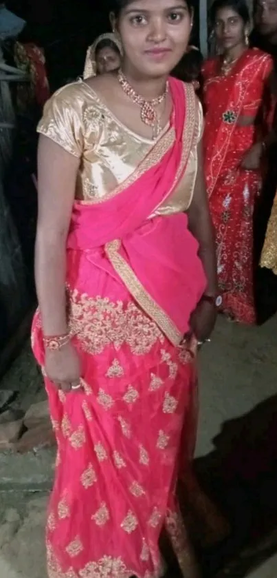 Elegant lady in vibrant pink traditional attire posing confidently.