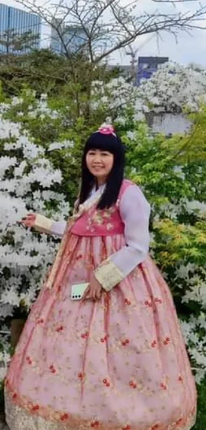 Two women in traditional Korean hanbok amidst lush greenery.