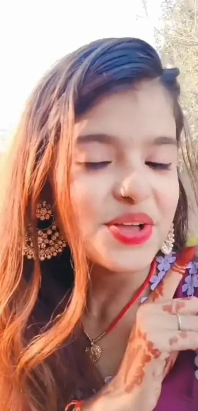 Woman in traditional attire with jewelry outdoors.