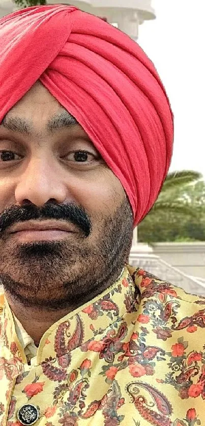 Person with red turban in traditional attire.