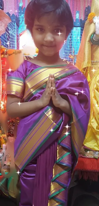 Child in traditional saree with colorful decor and sparkling accents.