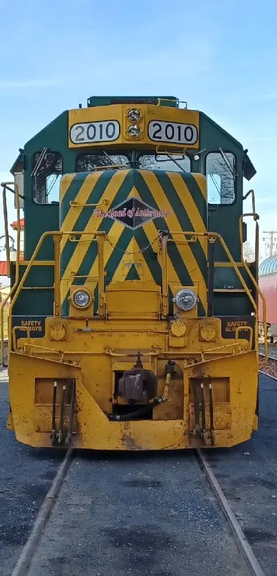 Vibrant yellow and green train on railway track.