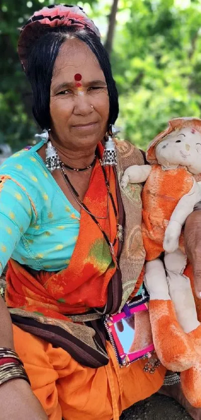 Tribal woman holding a doll with vibrant attire and background.