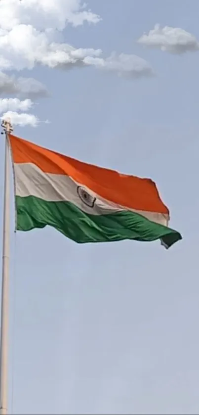 Vibrant tricolor flag flying high in a clear blue sky.