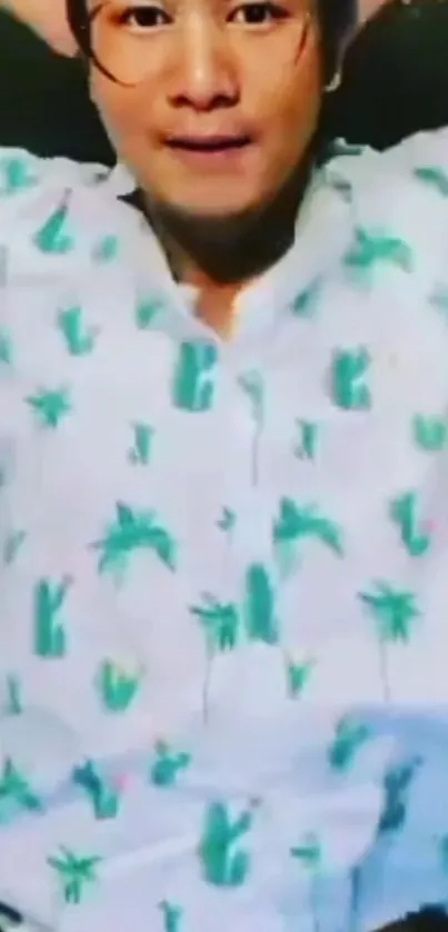 Person wearing tropical print shirt with palm motifs.