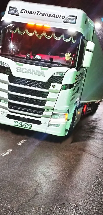 White Scania truck on wet road with vibrant night lights.