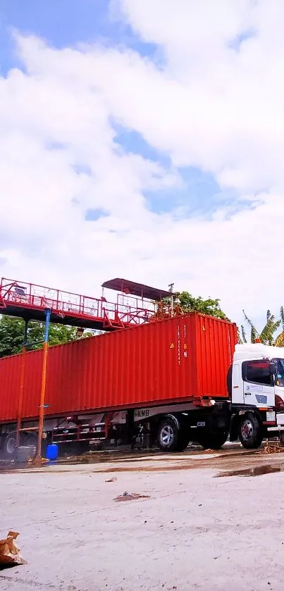 Red truck and container under a blue sky, vibrant transport wallpaper scene.