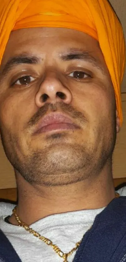 Man with vibrant orange turban portrait.