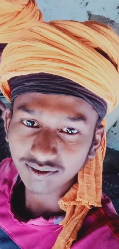 A vibrant selfie with an orange turban for phone wallpaper.