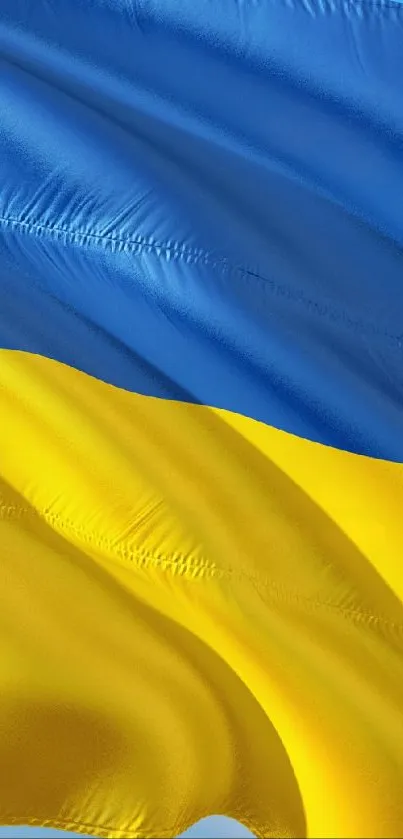 Vibrant Ukrainian flag with blue and yellow stripes waving against the sky.