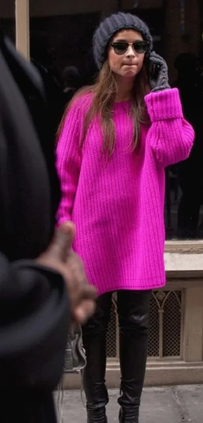 Fashionable woman in a bright magenta sweater on a city street.