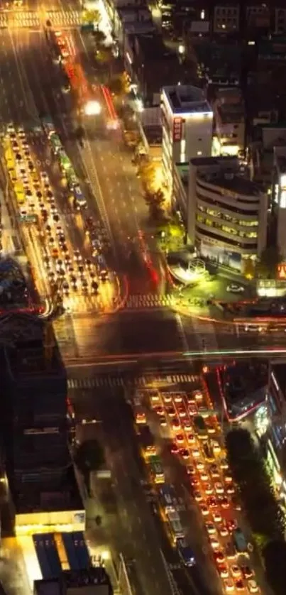 Aerial view of a vibrant city with busy roadways and glowing lights at nighttime.