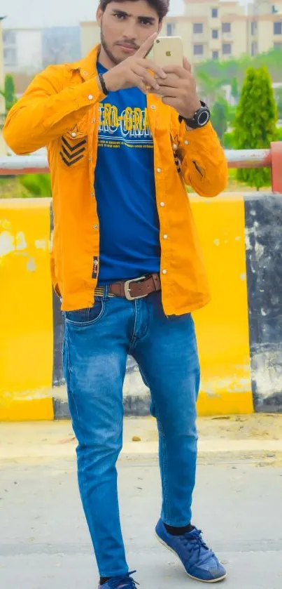 Fashionable individual in orange shirt captures urban style with vibrant backdrop.