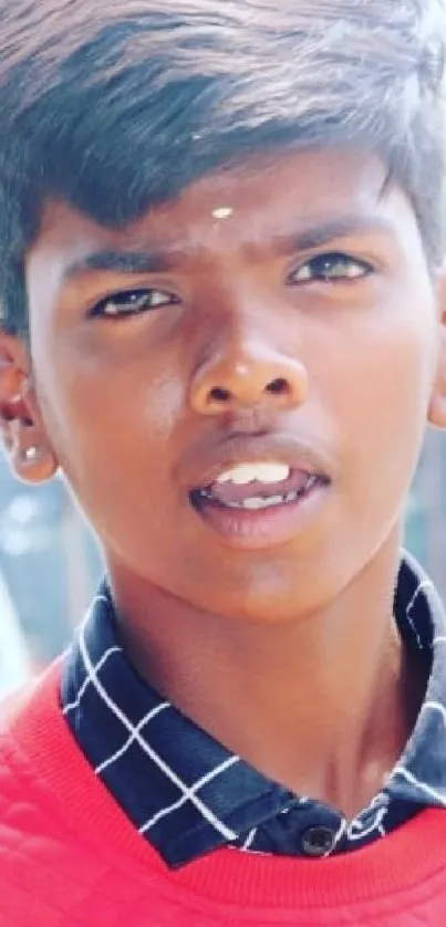 Young person in vibrant red outfit, urban background.