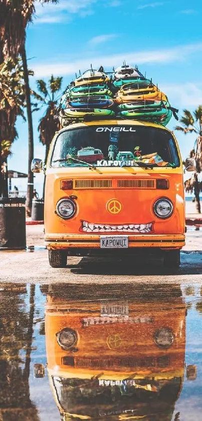 Orange van with surfboards on a sunny beach with palm trees.