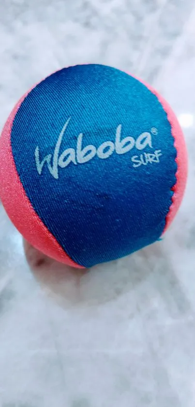 Colorful Waboba Surf ball on marble surface.