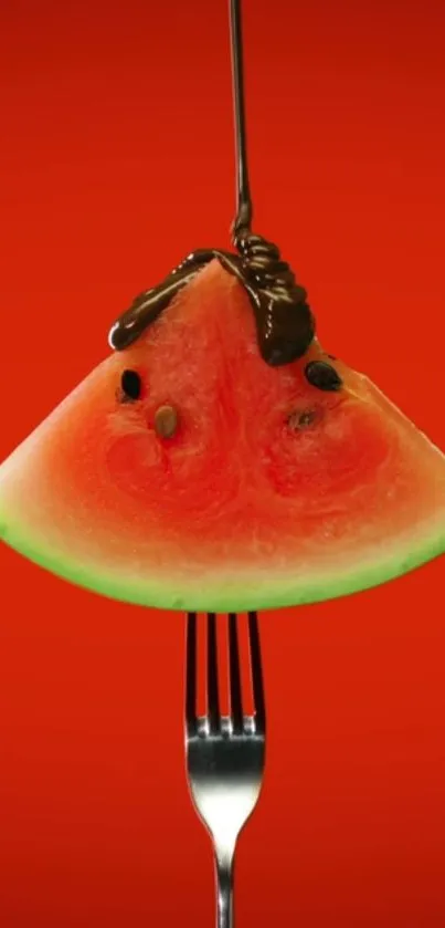 Watermelon slice on fork with chocolate on a red background.