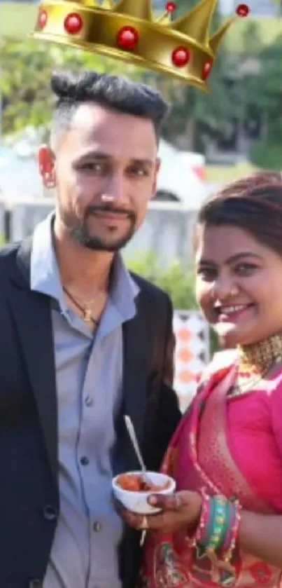 Smiling couple in vibrant traditional attire at a festive wedding celebration.