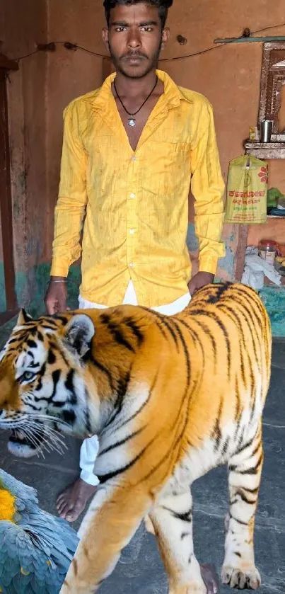 Man posing indoors with tiger and parrot.