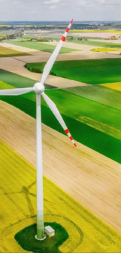 Aerial view of a wind turbine in vibrant green fields.