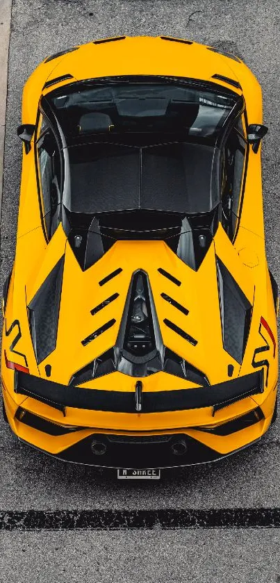 Top view of a vibrant yellow sports car on a city street.