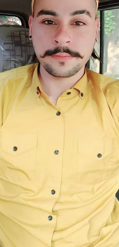 Man in vibrant yellow shirt and cap sitting.