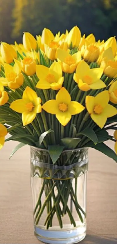 A vibrant bouquet of yellow flowers in a clear glass vase outdoors.