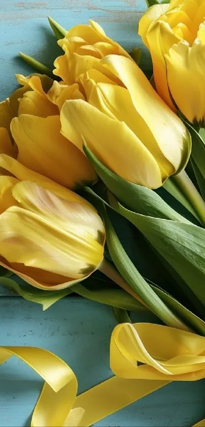 Vibrant yellow tulips on teal wood background.