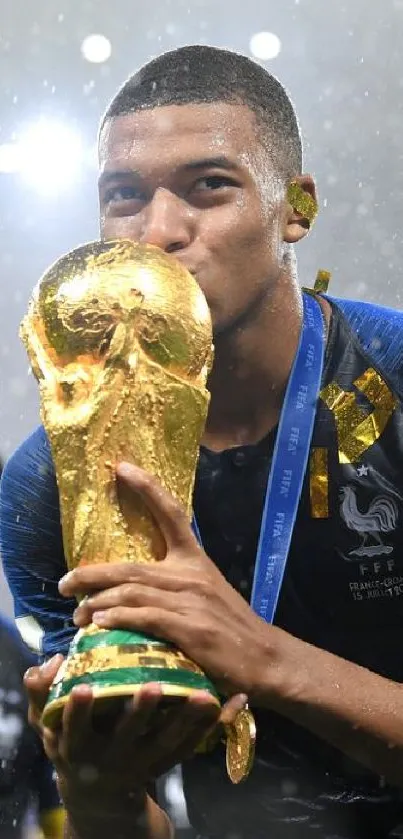 Soccer player celebrates with trophy in blue uniform, capturing victory moment.