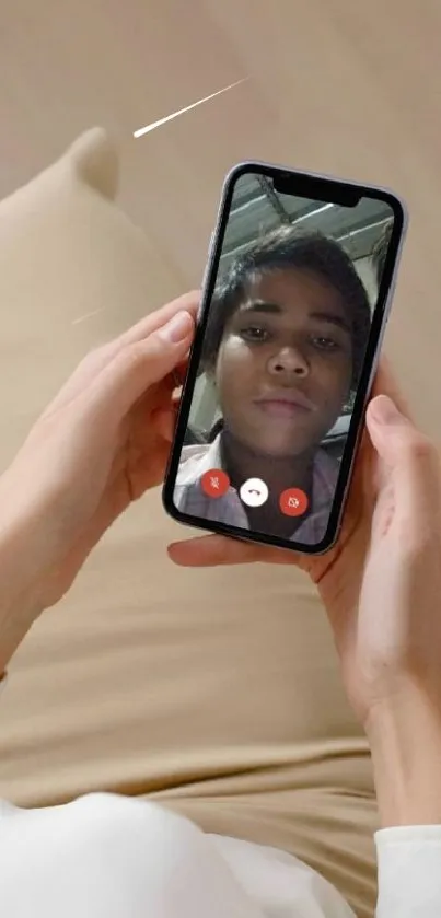 Person holding smartphone with video call wallpaper.