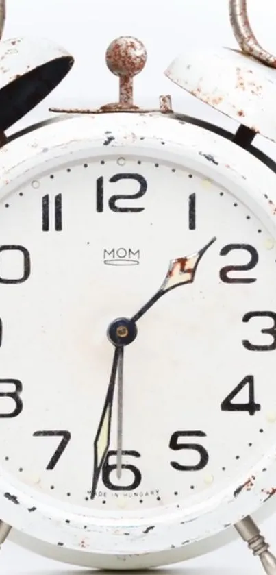 Vintage white alarm clock with rust details.