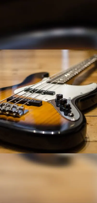 Vintage bass guitar laying flat on a wooden floor, showcasing a classic design.