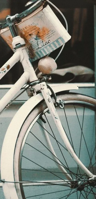 A vintage white bicycle against a teal background, evoking nostalgia and charm.