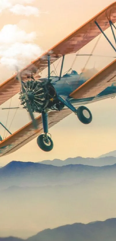 Vintage biplane flying over misty mountains in an atmospheric sky.