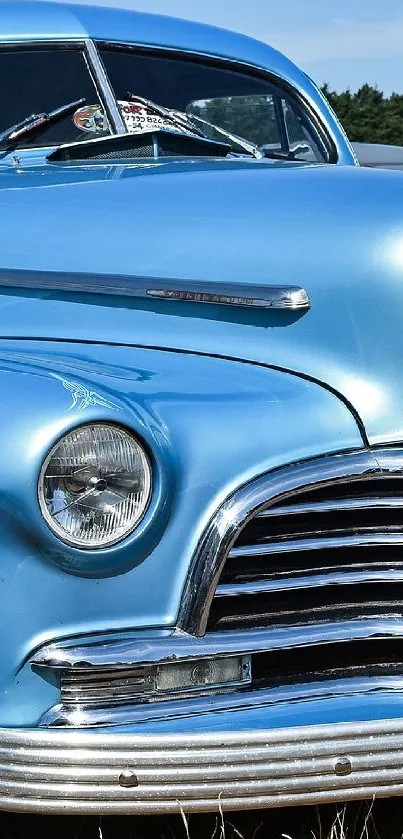 A vintage blue car on a field, showcasing classic design and retro charm.